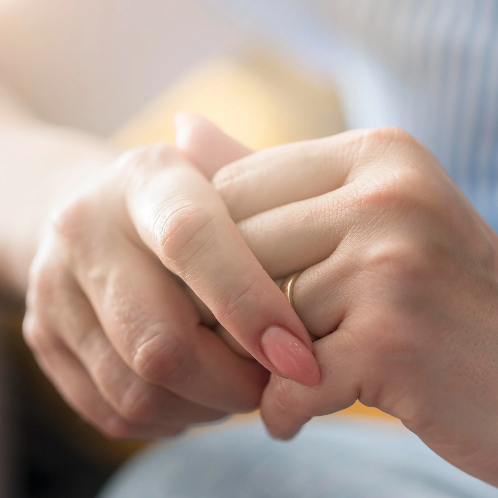 Patient holding a clinician's hand during a behavioral health consultation